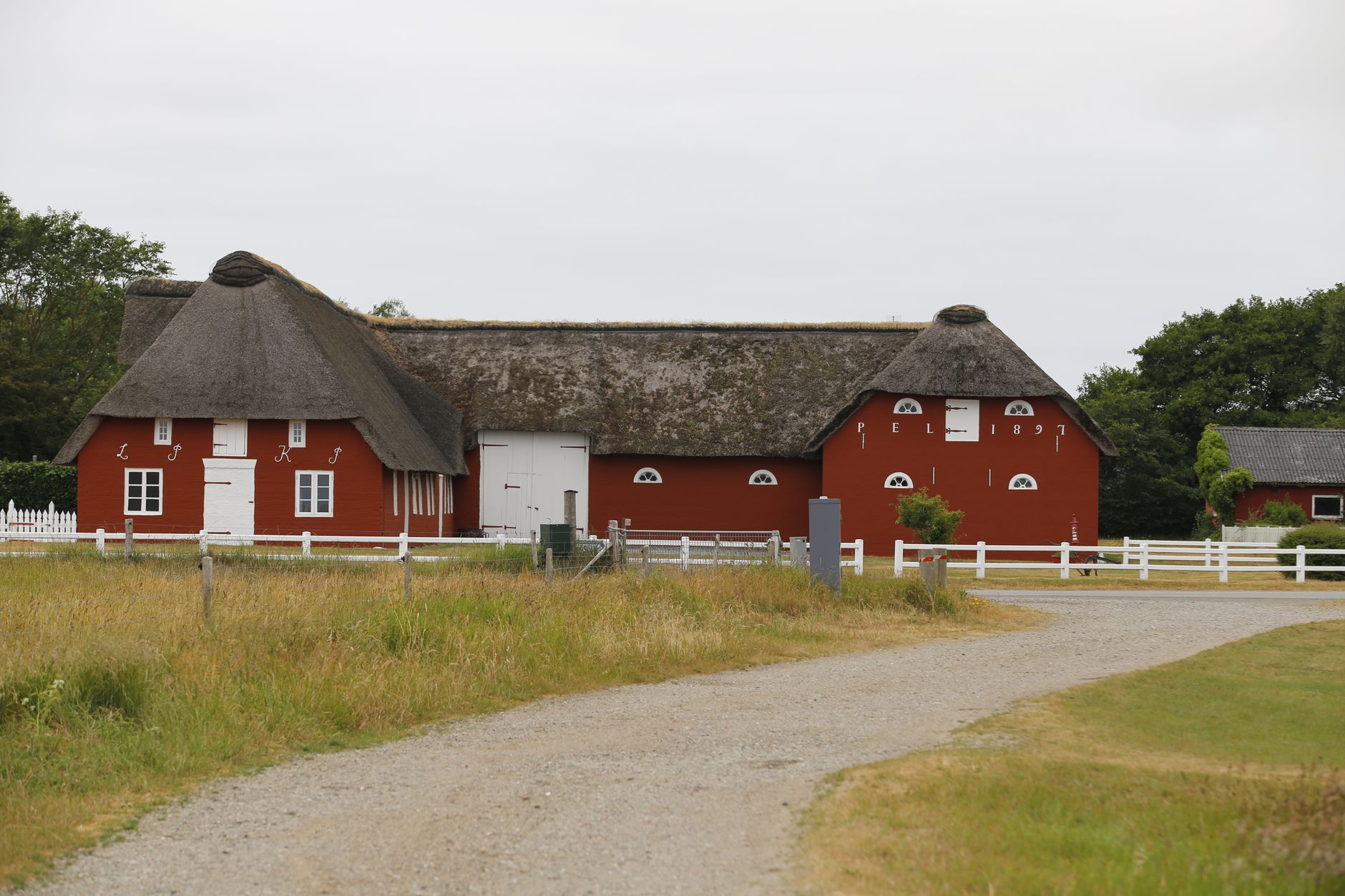 Gårde og marker i et fladt landskab ved vestkysten